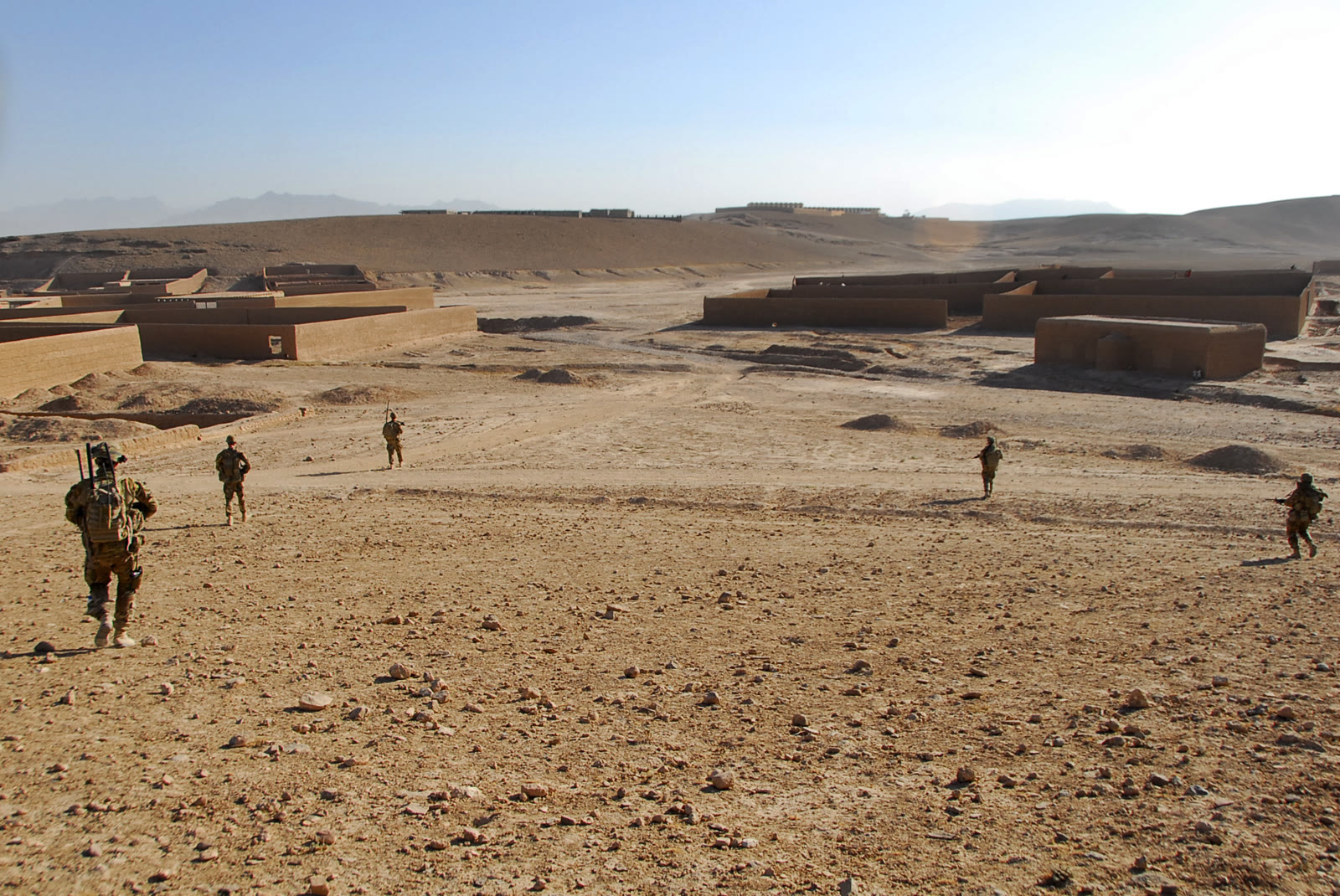 Australian soldiers on patrol across open ground in Tarin Kowt, Uruzgan Province